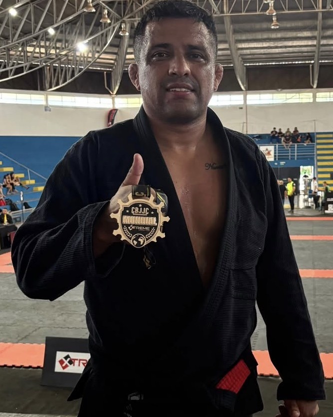 Professor Everton Frota, faixa preta de jiu-jítsu, de kimono preto com medalha de campeonato